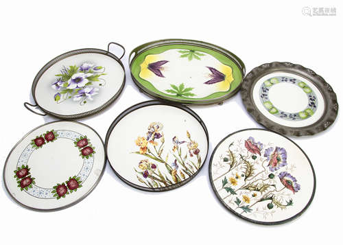 A collection of early 20th Century continental pottery and base metal trays and platters, each