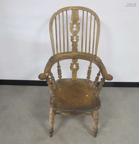 A 19th century elm hoop backed Windsor arm chair, pierced centre back splats, raised on turned