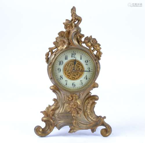 A late 19th or early 20th Century gilt metal mantel clock raised on four scrolling feet, the