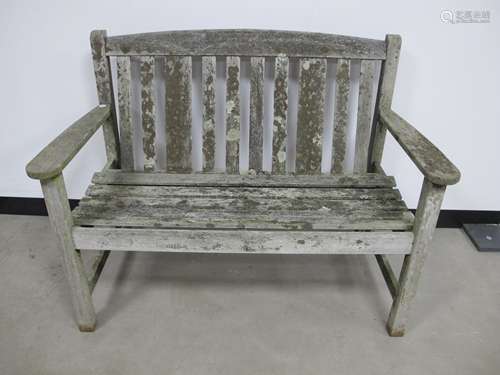 A weathered two seater teak garden bench, made by Listers, 114cm x 59cm x 86cm