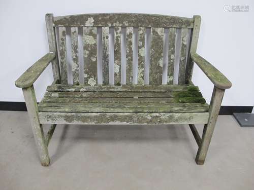 A weathered two seater teak garden bench, made by Listers , 114cm x 59cm x 86cm