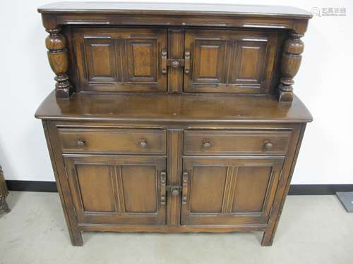 An Ercol style court cupboard, two door cupboard to top section above two frieze drawers with two