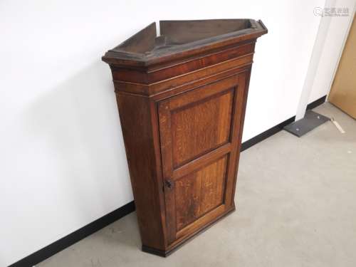 An Oak corner cupboard with four internal shelves, together with key. 120cm x 80cm x 42cm