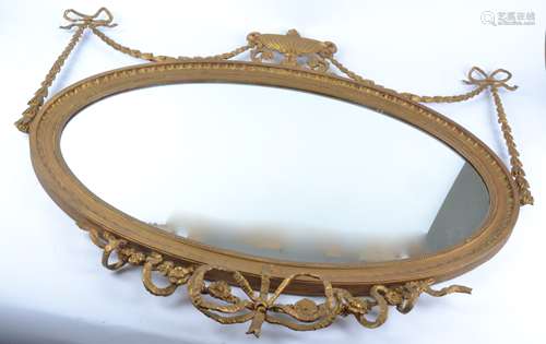 An oval giltwood mirror with swags and bows and covered urn decoration, height 90cm x 107cm AF in