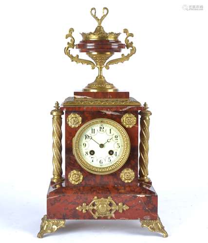 A 19th Century French red marble mantel clock, white enamel dial with Arabic numerals, flanked by