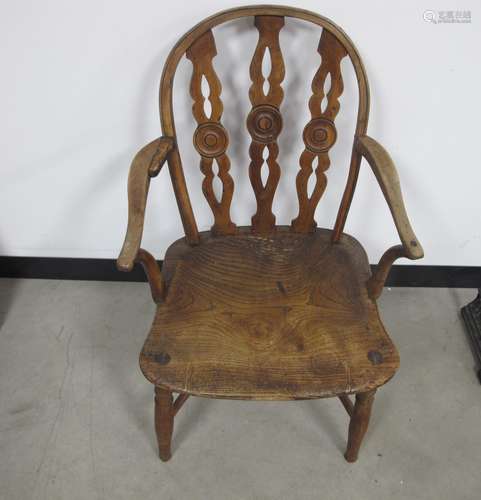 An antique hoop back Windsor arm chair, elm seat, three pierced slates to back with a central target