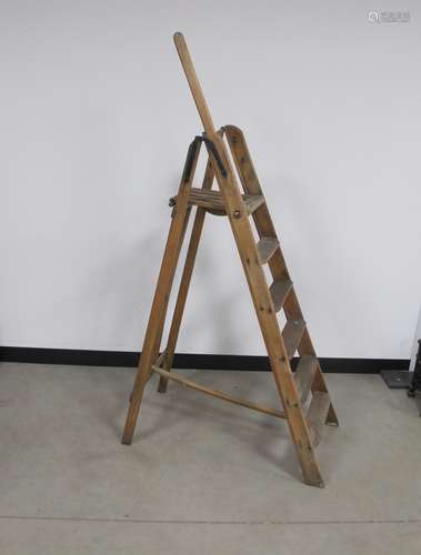 A vintage wooden hardwood folding step ladder, five steps plus platform, with a holding rail to