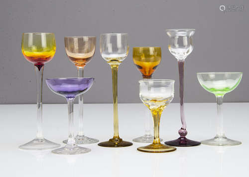 Two shallow bowl liquor glasses, one in amethyst the other in green with colourless glass stems