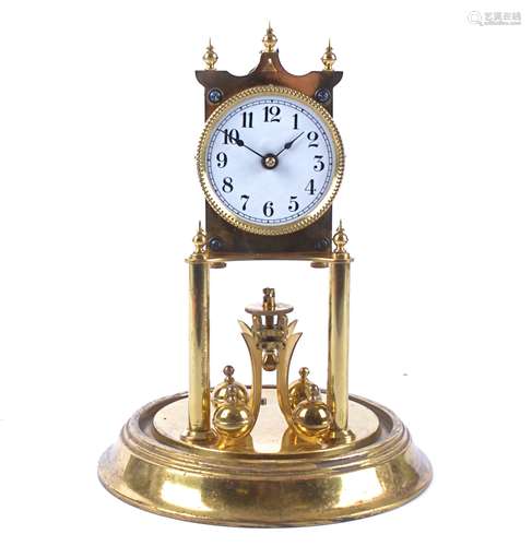 A 1930's brass torsion pendulum clock, white enamel dial with Arabic numerals, underneath a glass