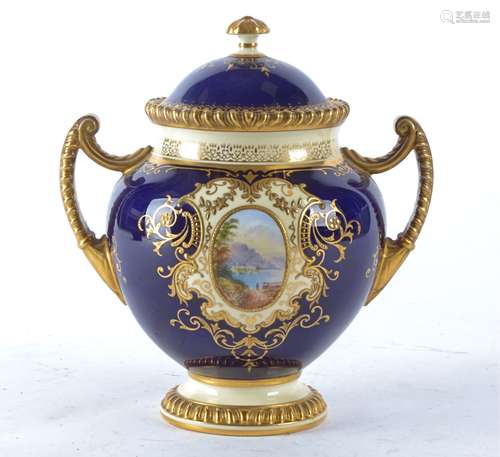 A late 19th Century Coalport twin handled urn and cover, with cartouches of lakeside landscapes, the