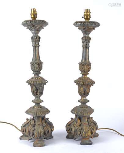 A pair of early 20th Century gilt cast plaster lamp bases, raised on three scrolling feet, with