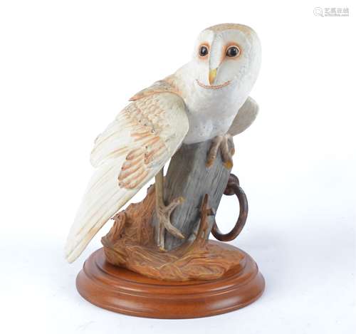 A Franklin Mint bisque porcelain sculpture of 'The Barn Owl', raised on a circular wooden stand,