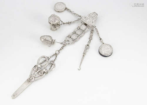 A fine 19th Century chatelaine, the belt hook with raised floral design, supporting seven fancy link