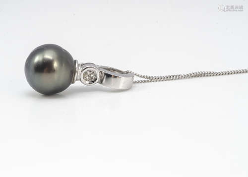 A cultured black pearl and diamond drop pendant, in white metal marked 14k 585 on a fine 9ct white