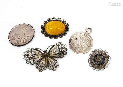 Five silver brooches, including a filigree butterfly, a butterscotch amber with filigree mount, an