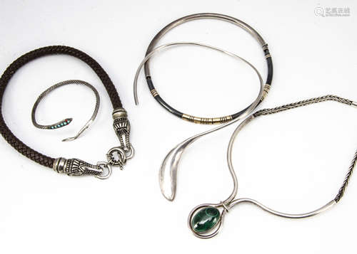 A collection of silver and white metal torques and necklaces, including a plaited leather and