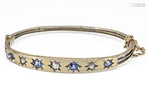 An early 20th Century yellow metal sapphire and diamond bangle, the satin top set with old cut