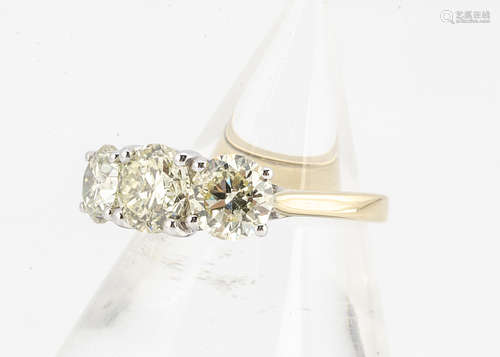 A certificated 18ct white and yellow gold diamond set trilogy ring, the brilliant cut claw set