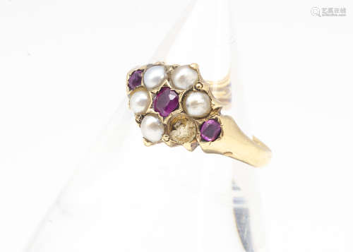 A George V pearl and ruby dress ring, the cluster style ring with ruby set shoulders, one half pearl
