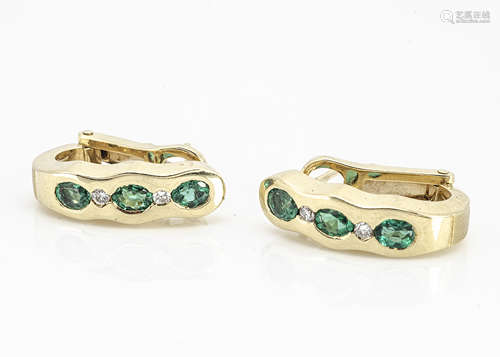 A pair of contemporary continental yellow metal emerald and diamond ear clips, with oval cut