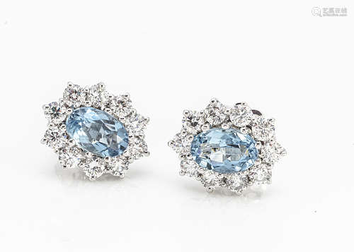 A pair of aquamarine and diamond white 18ct gold cluster ear studs, oval mixed cut central