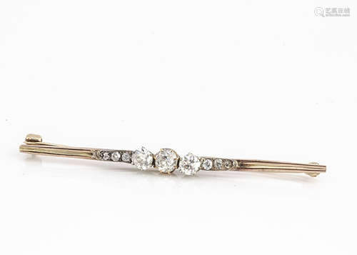 An Edwardian gold and platinum tipped diamond bar brooch, the old cut diamonds in claw setting