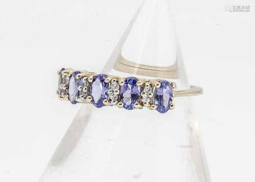 A 9ct gold tanzanite and white sapphire dress ring, the oval claw set tanzanites alternately set