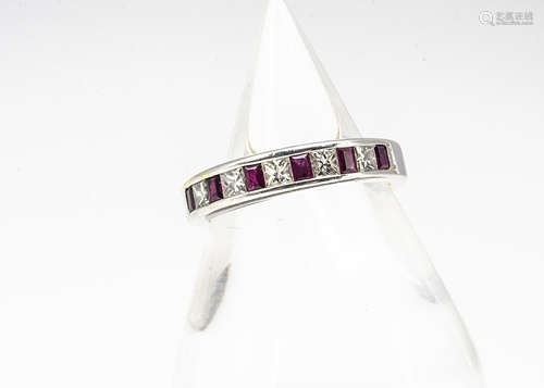 A white metal ruby and diamond half hoop eternity ring, the mixed rectangular cut rubies alternately