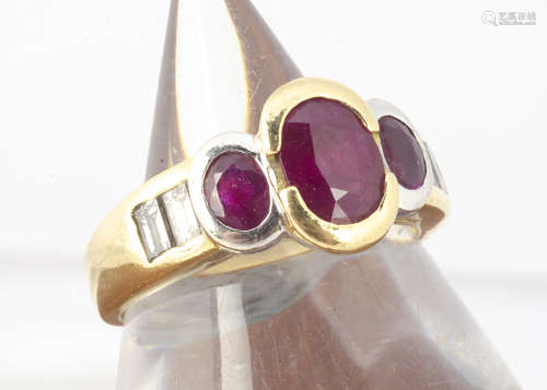 An 18ct gold three stone ruby and diamond set dress ring, the three oval cut rubies in rubbed over