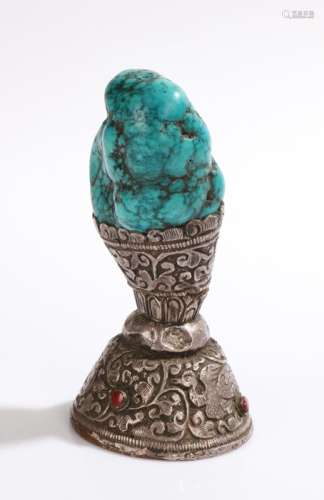 Tibetan seal, the turquoise handle above a white metal foliate and bird decorated base, 10.5cm high