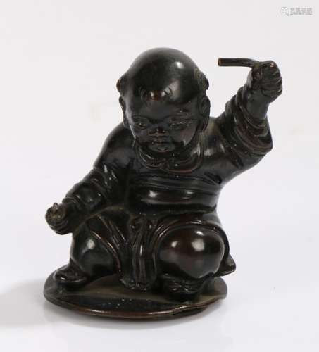 Chinese bronze figure depicting a baby holding a stick to each hand, 9cm high