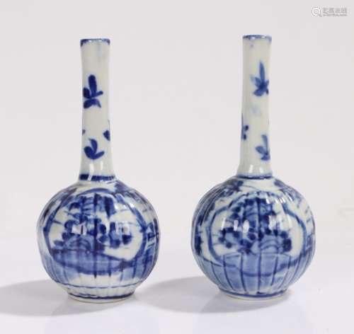 Pair of blue and white spill vases, the slender necks above gadrooned bulbous bodies, with foliate