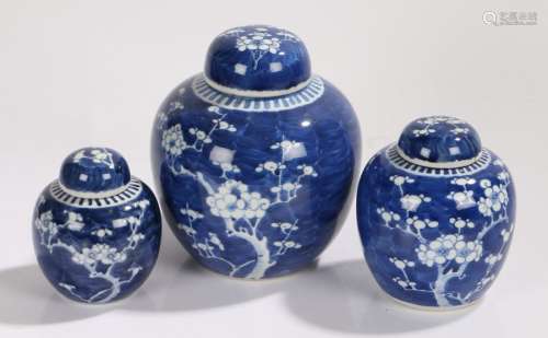 Graduated set of three Japanese ginger jars, with prunus blossom decoration on a blue ground, the