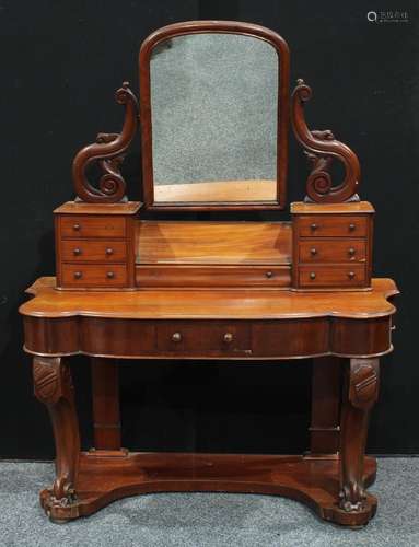 A Victorian mahogany dressing table, arched rectangular mirror flanked by scrolling supports pierced