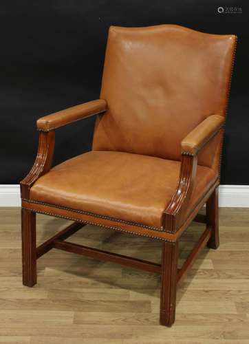 A George III style mahogany Gainsborough armchair, stuffed over tan upholstery, brass studded