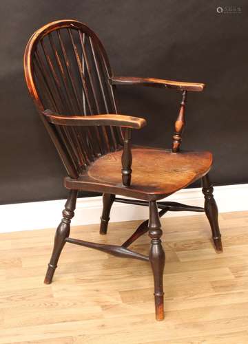 A 19th century elm and ash Windsor elbow chair, arched stick back, serpentine arms, saddle seat,