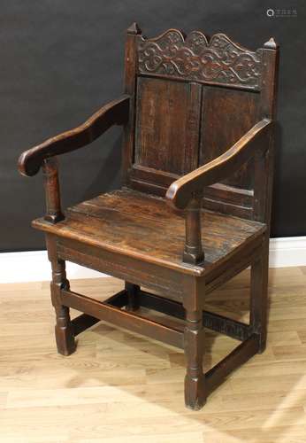 A '17th century' oak Wainscote armchair, shaped cresting rail carved with strapwork and flanked by