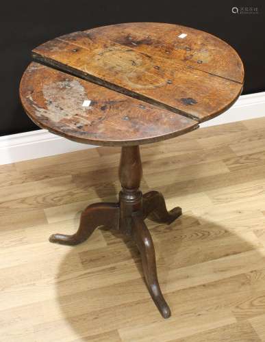A George III oak tripod occasional table, circular tilting top, slender baluster pillar, cabriole