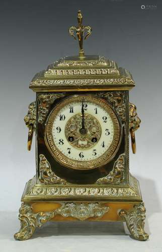 A brass mantel clock, ivorine chapter ring, Arabic numerals, twin winding holes, pair of lion mask