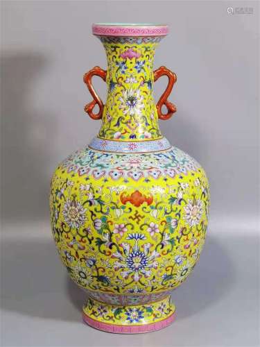 A QING DYNASTY QIANLONG FAMILLE ROSE YELLOW GROUND FLOWER OF LONGEVITY AND HAPPINESS BOTTLE WITH DOBBLE EARS
