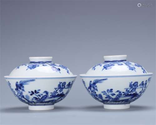 A pair of blue and white flower and bird covered bowls