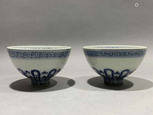 A pair of tea cups decorated with blue and white flowers