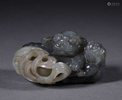 A QING DYNASTY BLUE AND WHITE CARVED JADE LOIN SHAPE ORNAMENT