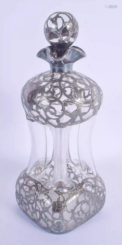 AN ART NOUVEAU SILVER OVERLAID DECANTER AND STOPPER.…