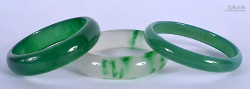 THREE CHINESE CARVED JADEITE BANGLES. 6.5 cm diameter.