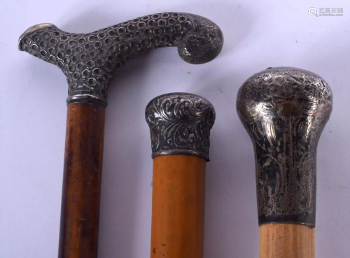 THREE ANTIQUE SILVER MOUNTED WALKING CANES. Larges…