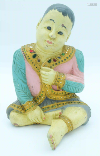A decorated wooden figure of an Asian Boy 31 x 22cm.