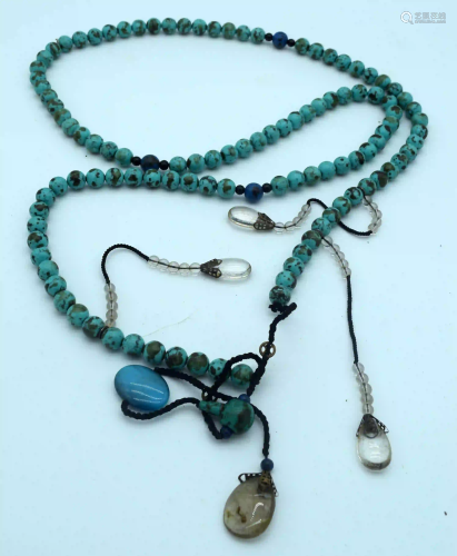 A long Turquoise stone necklace with hanging glass