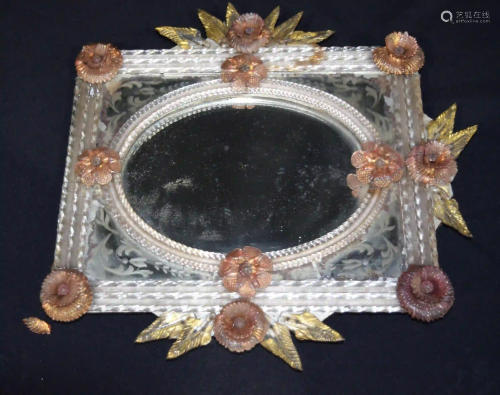 A glass framed mirror decorated with flowers and leaves