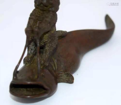 A Japanese small bronze Catfish being ridden by a